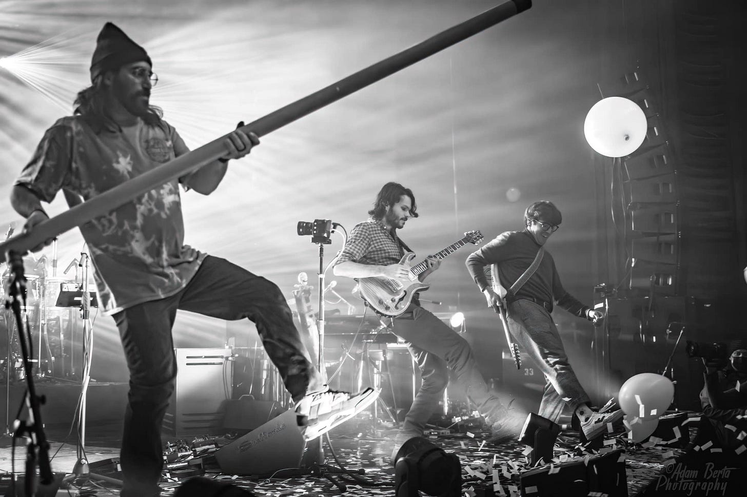 May be a black-and-white image of 3 people, people playing musical instruments, people standing and guitar