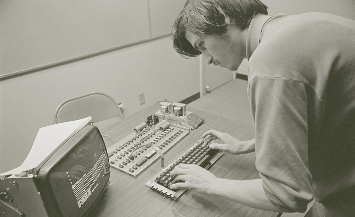A photo depicting Steve Jobs at work on an Apple I, 1976.