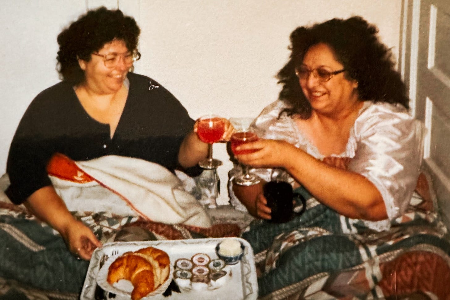 two women toast with juice over mothers day breakfast
