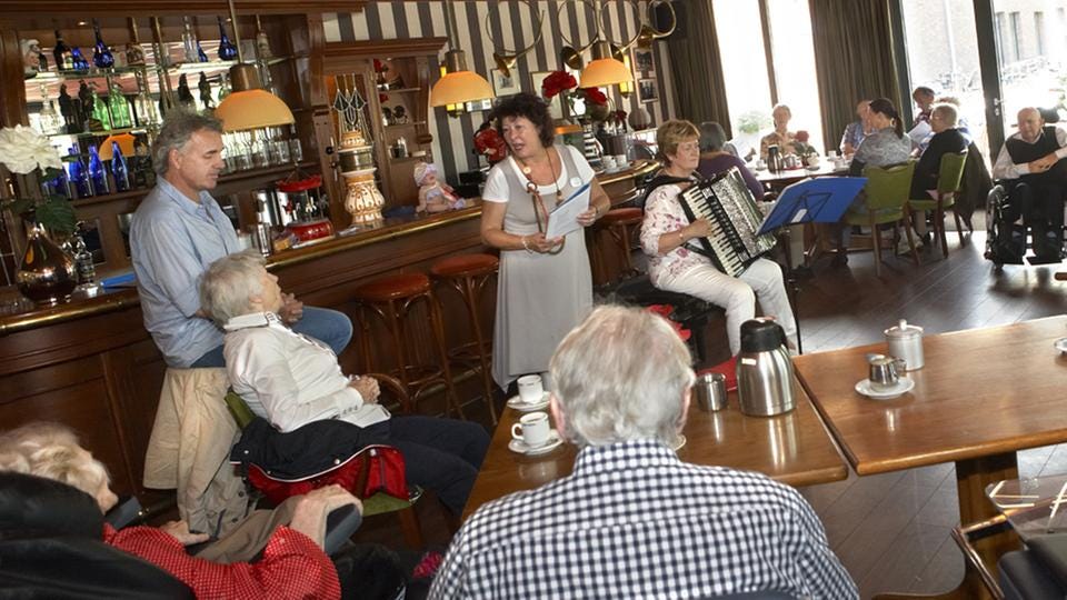 A scene from the Hogeweyk restaurant, where patrons from the residence and from the village mix for food and music. A scene from the Hogeweyk restaurant, where patrons from the residence and from the village mix for food and music.