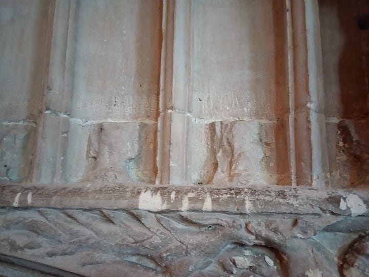 Bases of destroyed stone statuettes on wall above Hugh Despenser tomb