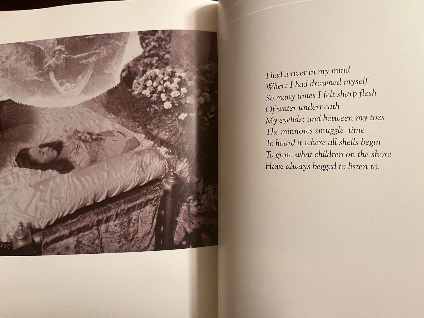 A woman lies deceased in a coffin and is accompanied by a poem: "I had a river in my mind / Where I had drowned myself / So many times I felt sharp flesh / Of water underneath / My eyelids; and between my toes / The minnows smuggle time / To hoard it where all shells begin / To grow what children on the shore / Have always begged to listen to."