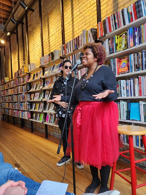 Various poets standing or sitting in Milkweed Bookstore, in front of filled bookcases, reading poetry.