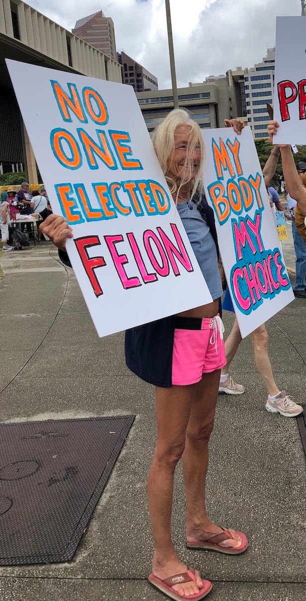 Reka holding two signs at the demonstration.