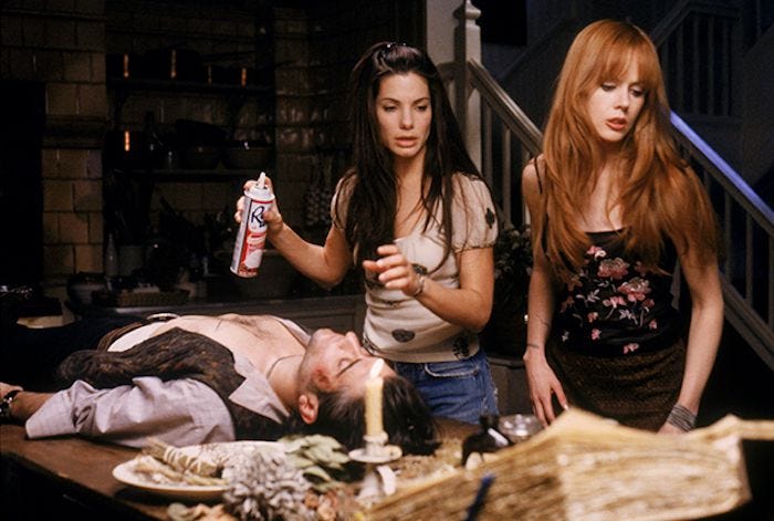 This may contain: two women standing next to a man laying on the ground in front of a table