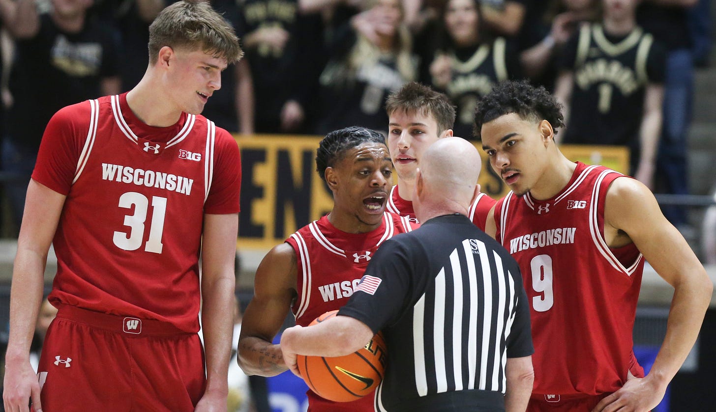 Wisconsin Badgers guard Kamari McGee (4) talks to an official after being ejected against Purdue. John Tonje and Jack Janicki are also pictured.