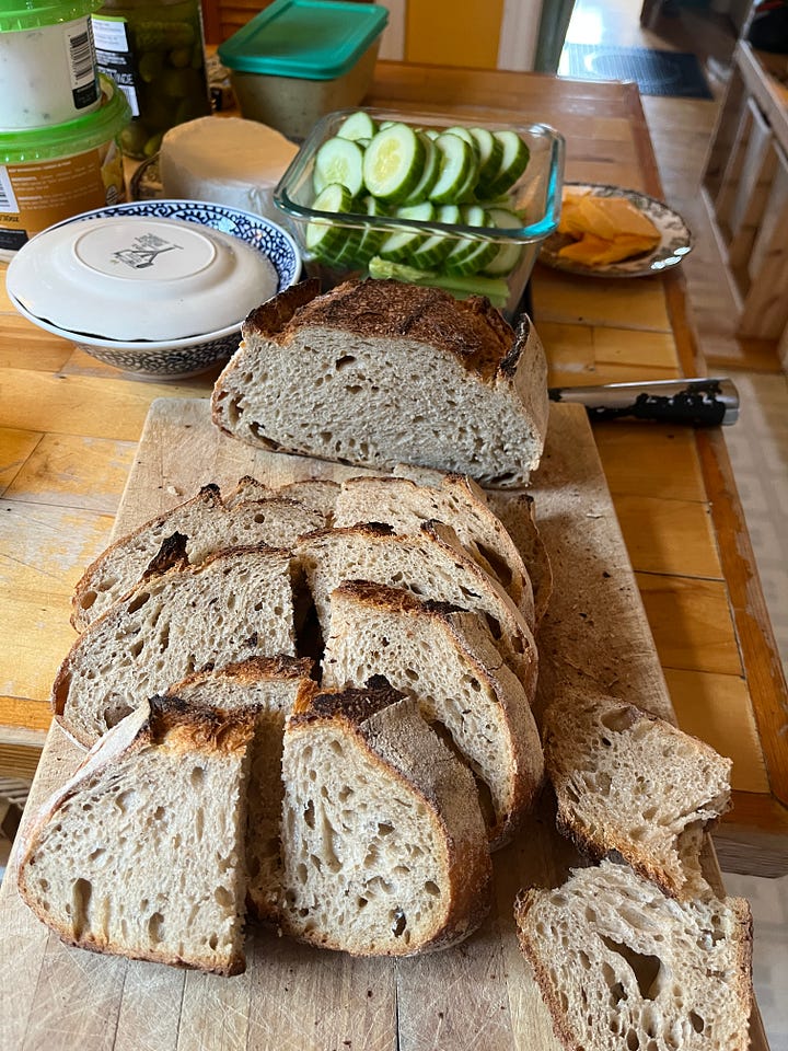 four images: 1 a jar of bubbly sourdough starter, 2 a tub of risen sourdough, 3, a loaf of bread on a cutting board, 4 the same loaf cut into pieces