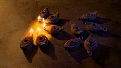 ten clay lamps sit on the ground. only five are lit.