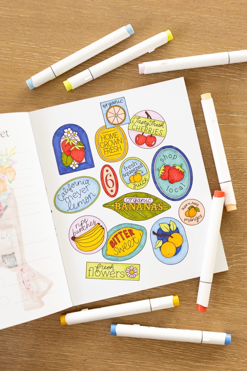 May include: A page of a notebook with colorful hand-drawn stickers featuring various fruits and vegetables. The stickers include lemons, bananas, cherries, mangoes, strawberries, and flowers. The stickers are labeled with phrases like "organic bananas", "ripe bunches", "tasty fresh cherries", and "home grown fresh".