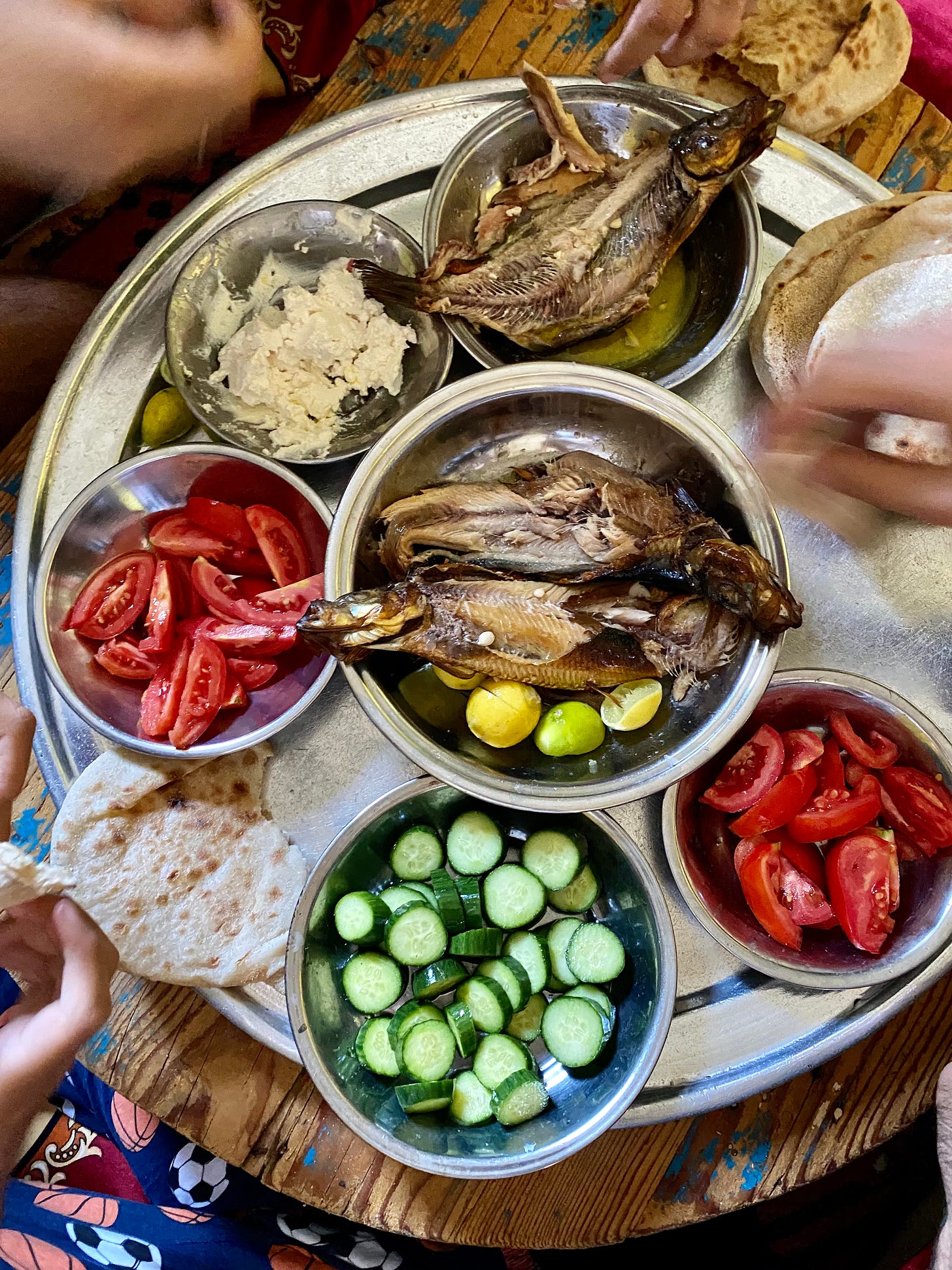 Smoked fish and small plates of tomatoes, cheese, and cucumbers
