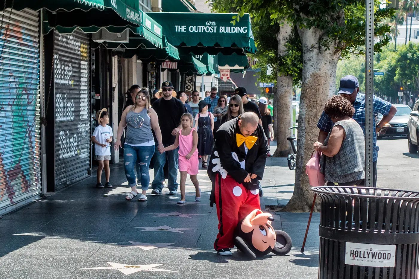 Photo of a man struggling with his Mickey Mouse costume on Hollywood Boulevard.