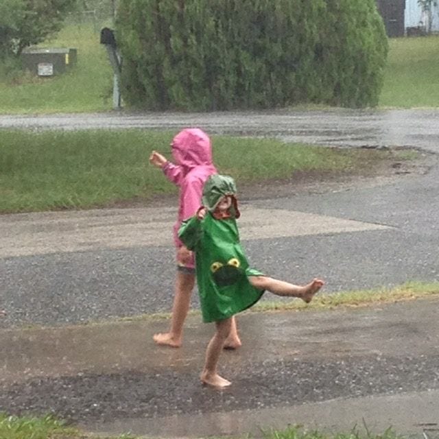 two fair skinned girls wearing rain coats out in the rain