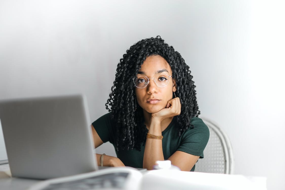 Free Serious ethnic young woman using laptop at home Stock Photo