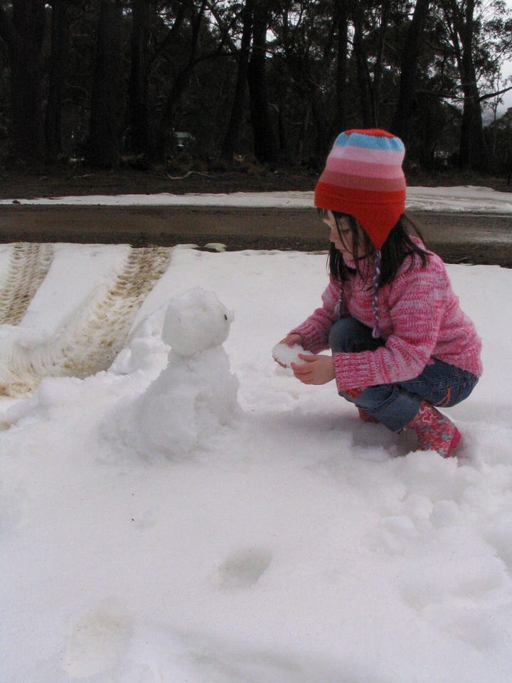 Children play and pose for photographs in snow in Tasmania