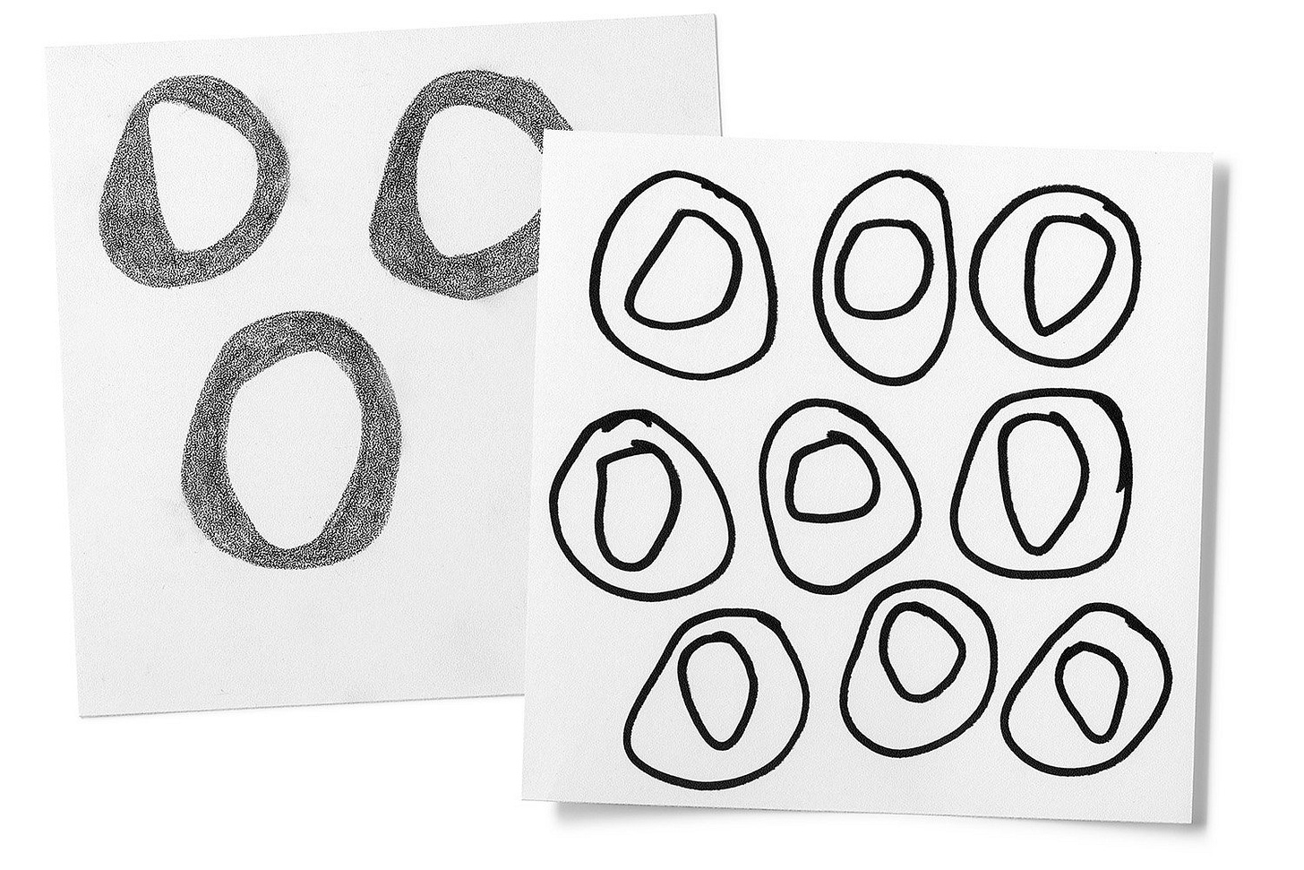 Two sheets of paper with hand-drawn ring-like motifs in black marker and stippled crayon.