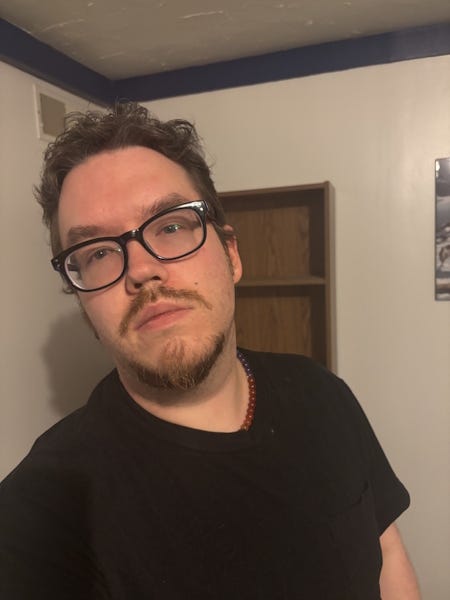 a photo of the author, in glasses and a black t-shirt