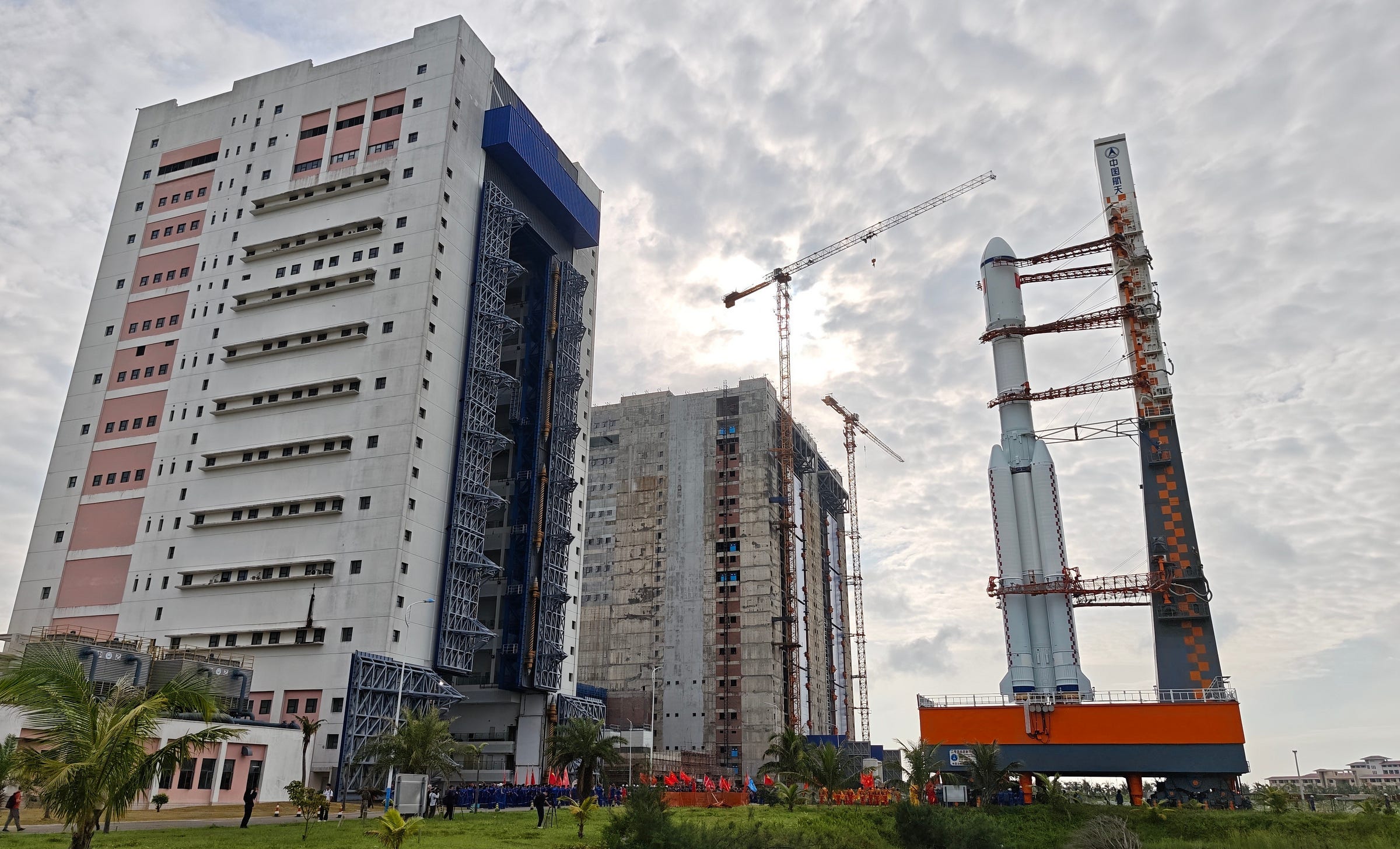 The Long March 7 Y10 vehicle rolling out from its assembly building for the Tianzhou-9 mission, with two new rocket assembly facilities under construction in the background. The Long March 7 Y10 vehicle rolling out from its assembly building for the Tianzhou-9 mission, with two new rocket assembly facilities under construction in the background.