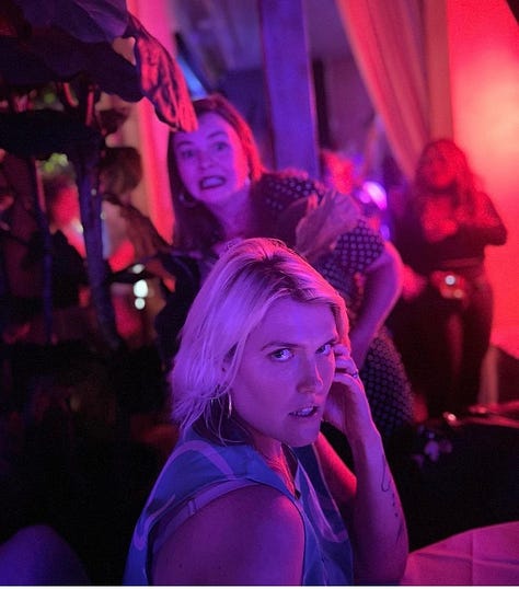 Five photos. Clockwise from top left: 1. Amber and Eliza take a selfie together outside. They both are laughing and wearing sunglasses. 2. In the foreground, Eliza gives a model look to the camera. In the background, Amber photobombs the picture, making a funny face. 3. Amber behind the scenes on the set of "Y: The Last Man." She stands staring into the camera with a large group of women behind her, also staring into camera. They all wear facemasks. 4. Amber, Ashley Romans, Eliza Clark, Marin Ireland, and Missi Pyle sit outside in the sun. They are all wearing big coats/hats/scarves and smile into camera. 5. Amber and Eliza stand chest-deep in the ocean facing each other. They are both laughing with their heads thrown back, not looking at the camera. They both wear sunglasses.