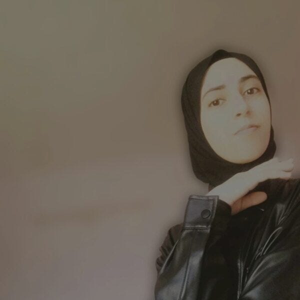 A young woman in hijab with hand under her chin. A young woman in hijab with hand under her chin.