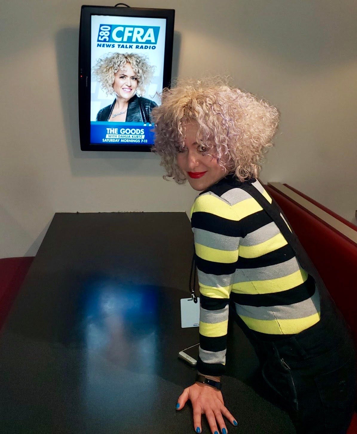 Dahlia Kurtz at Bell Media standing next to her show poster for 580 CFRA.