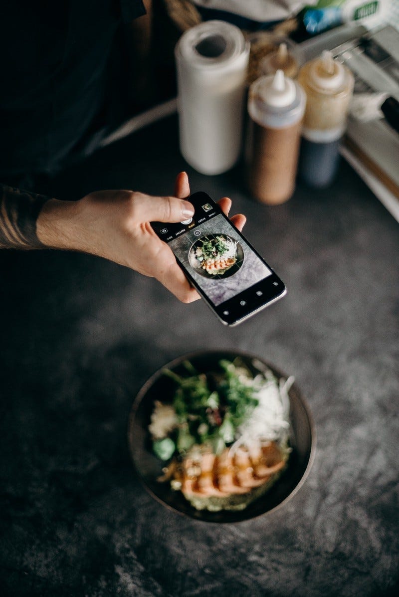 Man taking a photo of his food with his phone Man taking a photo of his food with his phone