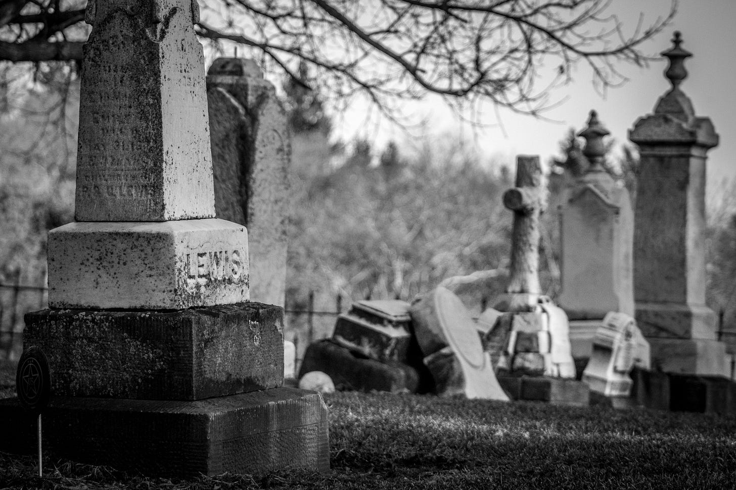 A black and white photo of tombstones in a cemetary.
