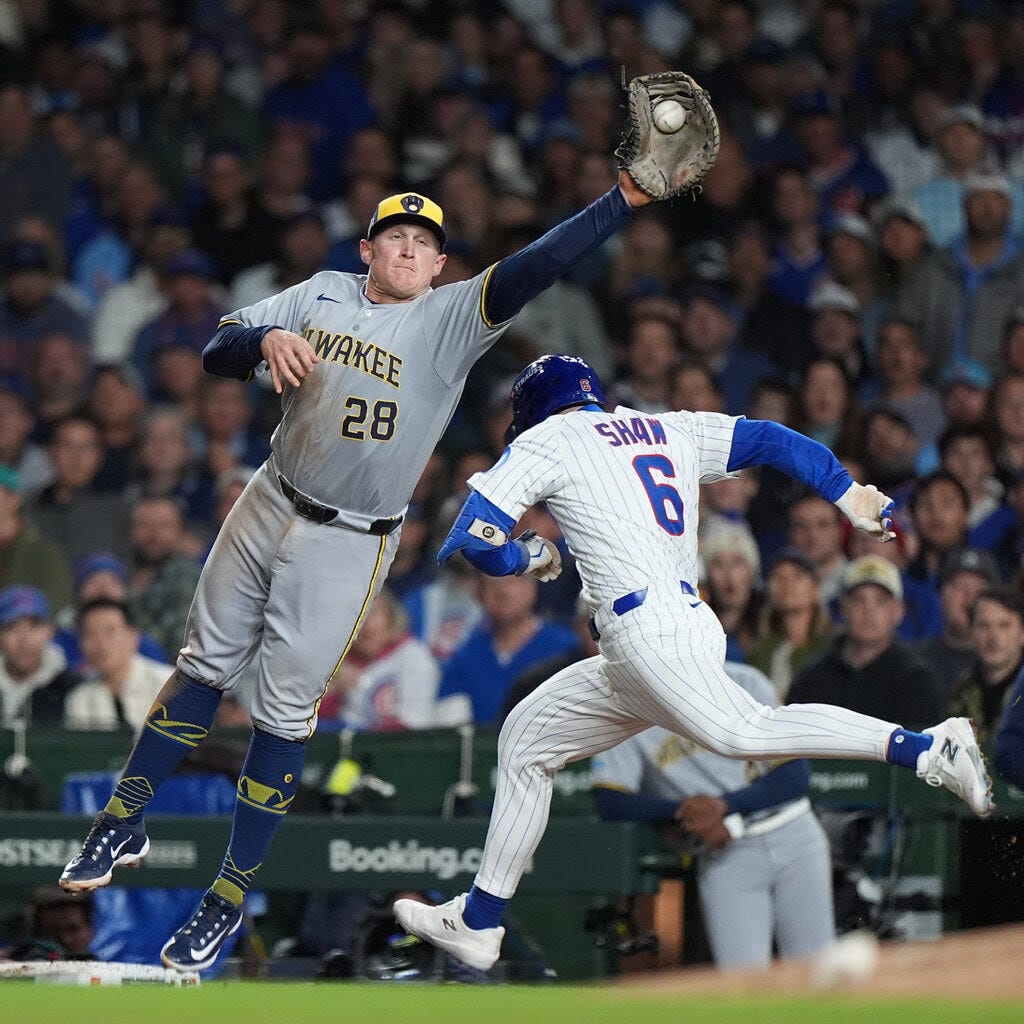 The Chicago Cubs’ Matt Shaw runs toward first base while the Milwaukee Brewers’ first baseman Andrew Vaughn reaches out to make a catch.