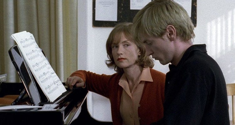 Isabelle Hupert staring at Benoît Magimel while he plays piano