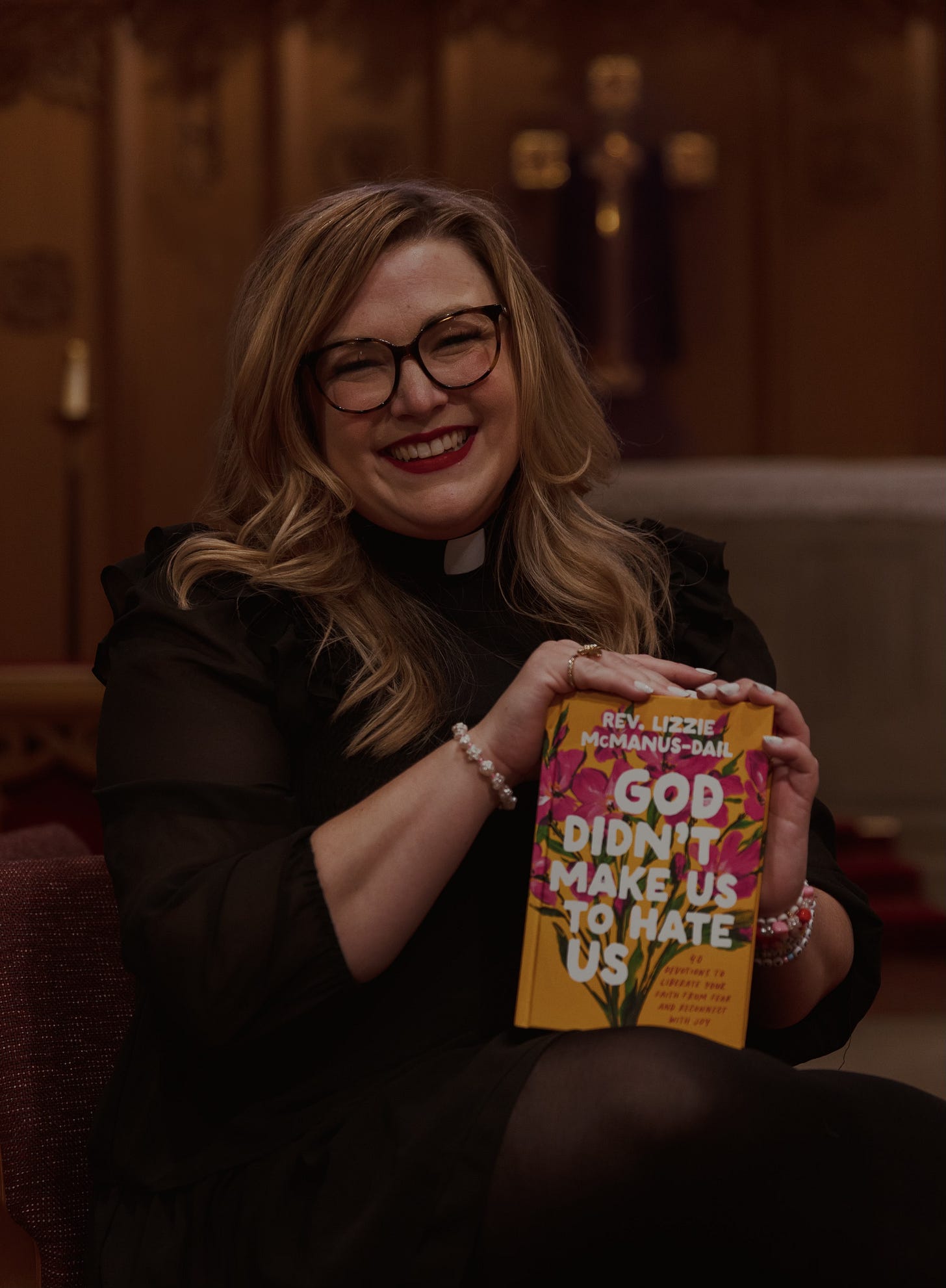 Rev. Lizzie holding her book, God Didn't Make Us to Hate Us
