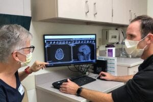Trial participant Kim Garland (left) reviews a scan with the study’s primary investigator, Tanner Johanns, MD, PhD, a WashU Medicine oncologist Trial participant Kim Garland (left) reviews a scan with the study’s primary investigator, Tanner Johanns, MD, PhD, a WashU Medicine oncologist