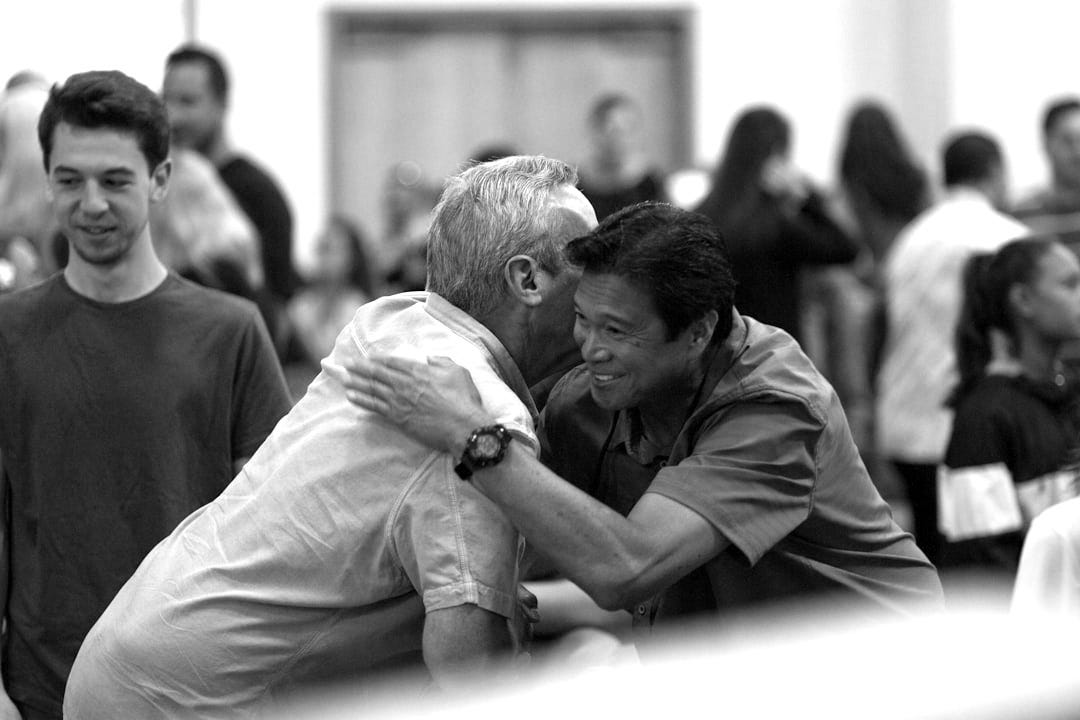 two men hugging on focus photography two men hugging on focus photography