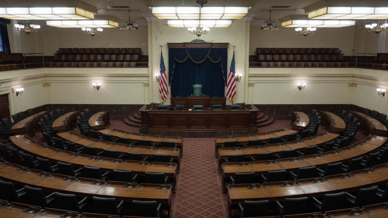 Empty state legislative chamber with curved wooden desks and raised dais Empty state legislative chamber with curved wooden desks and raised dais