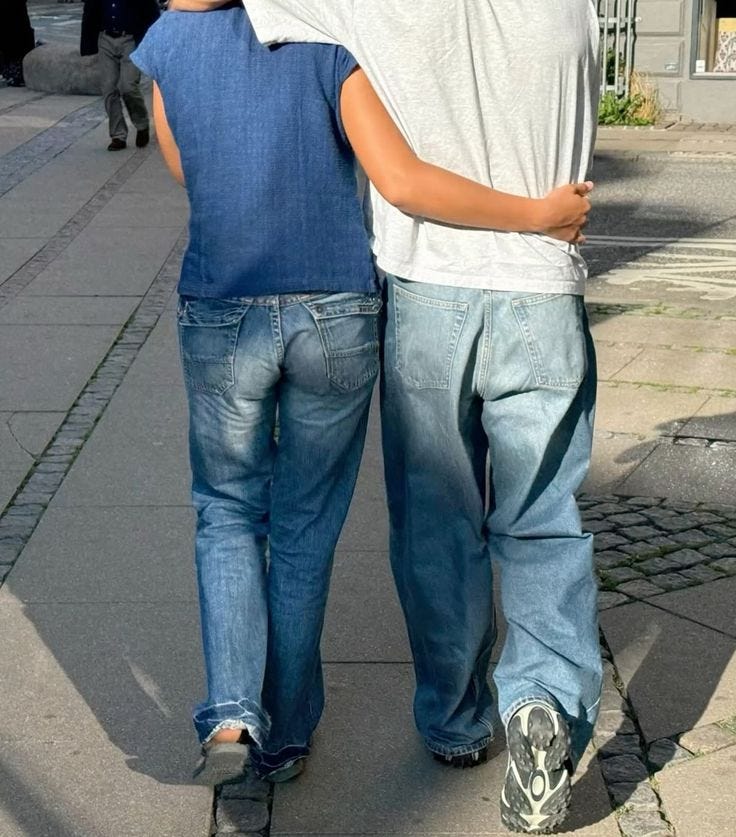 This may contain: two boys walking down the street with their arms around each other's shoulders, This may contain: two boys walking down the street with their arms around each other's shoulders,