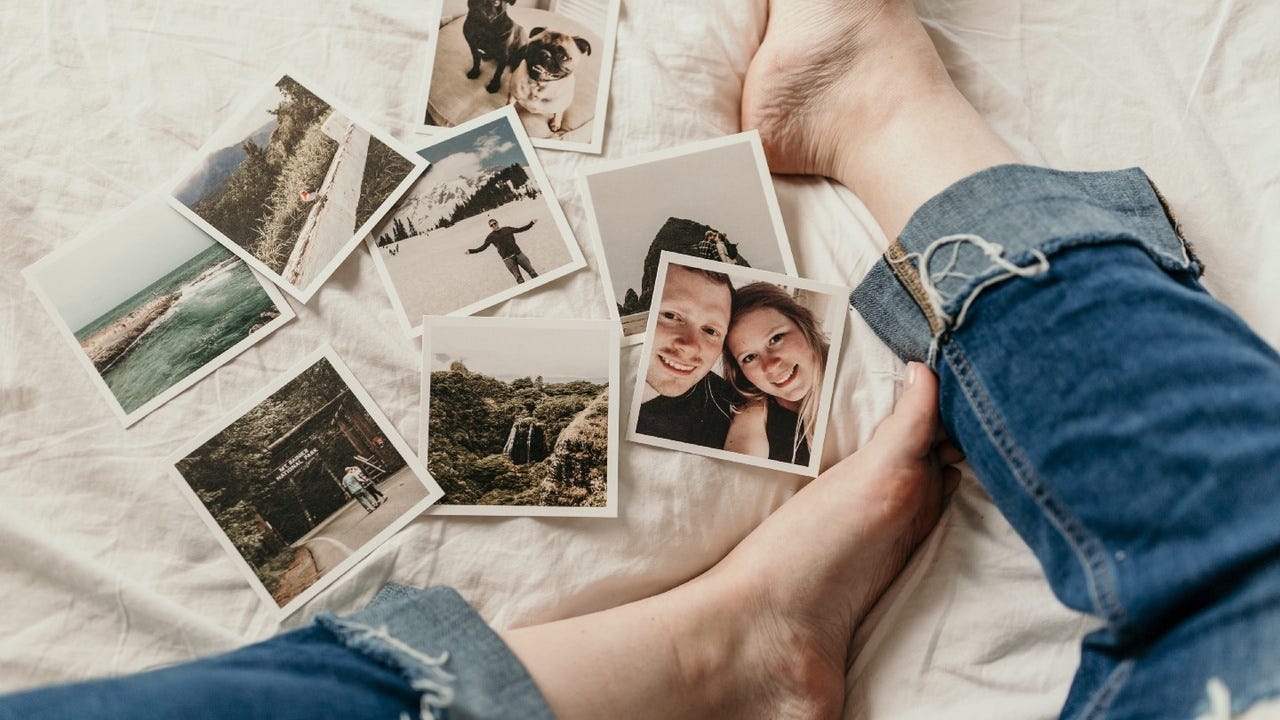 someone sitting cross legged in jeans surrounded by snapshots