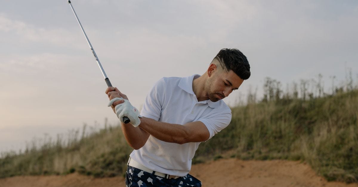 Photo: cottonbro studio / Pexels A focused male golfer taking a swing on a picturesque golf course during the day.