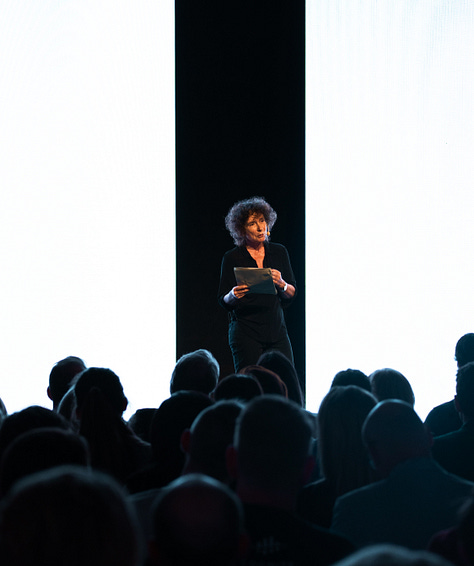 A gallery of 6 images showing close ups of the audience and zoomed out photographs of the Sana AI Summit stage.