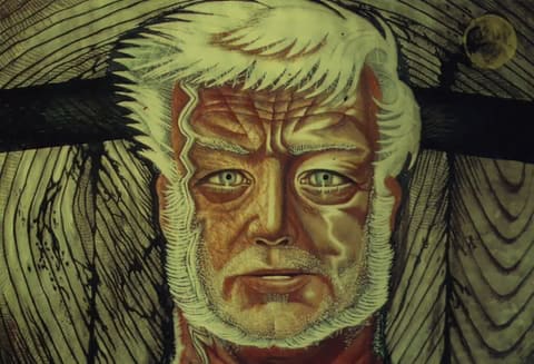 Close up of the face of Captain Ahab, a man with white hair and a white beard. He has a white lightening shaped mark down the side of his face.
