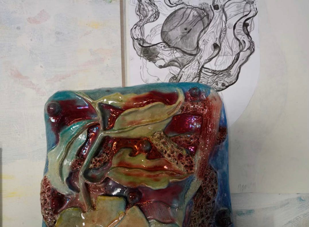 Studio of Italian artist Alessandro Roma: a richly glazed ceramic sculpture in the foreground, with an ink drawing on paper visible in the background. Photo by Mario Cresci, 2026. Curatorial project by Roberta Bertozzi.