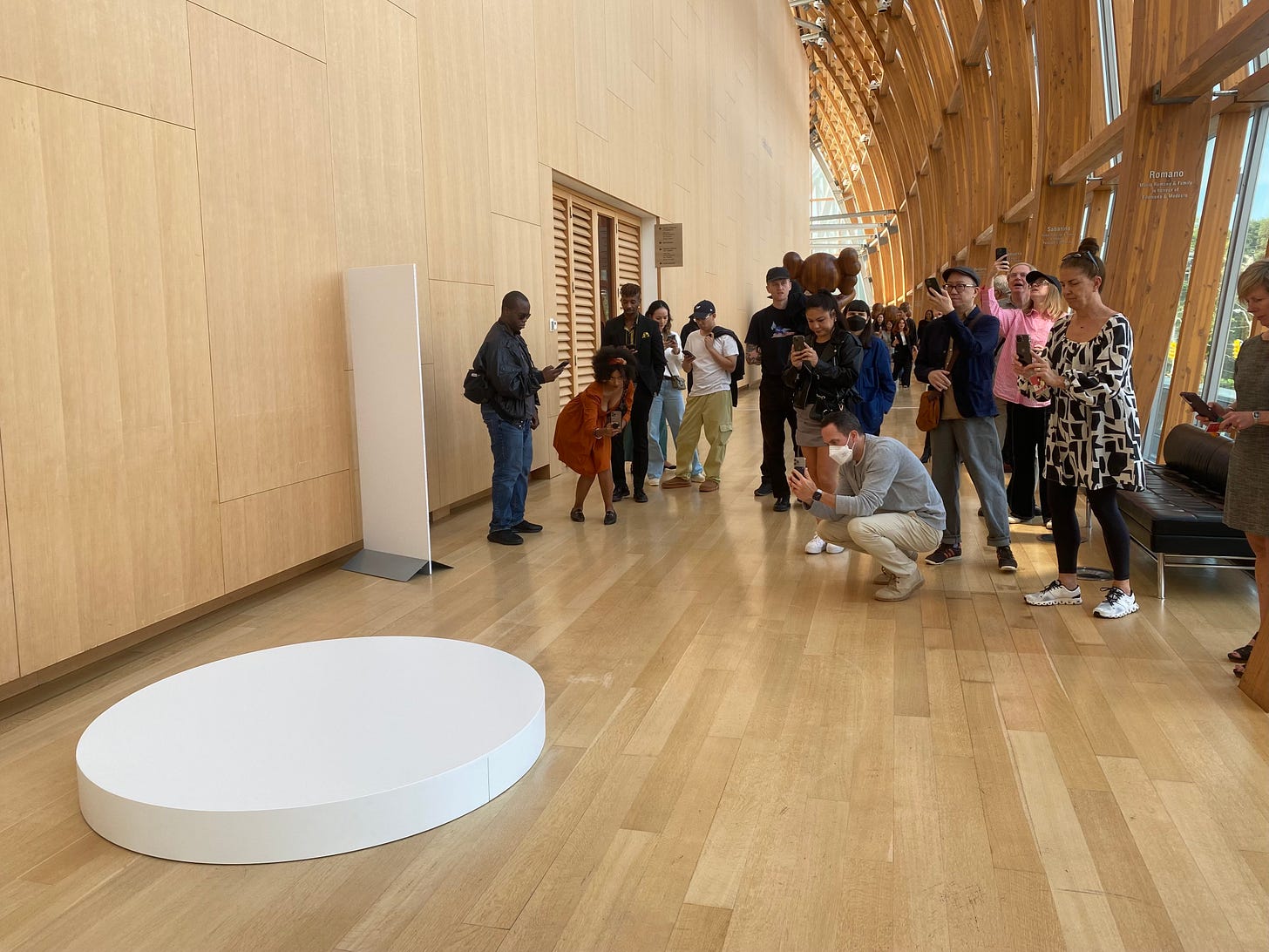 People taking photo of a blank pedastal/using AI