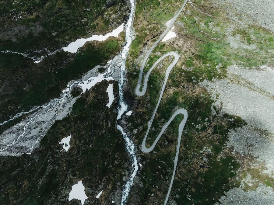 A winding mountain road bending back and forth beside a rushing river, reflecting the uncertain crossings and turning paths of the season. A winding mountain road bending back and forth beside a rushing river, reflecting the uncertain crossings and turning paths of the season.