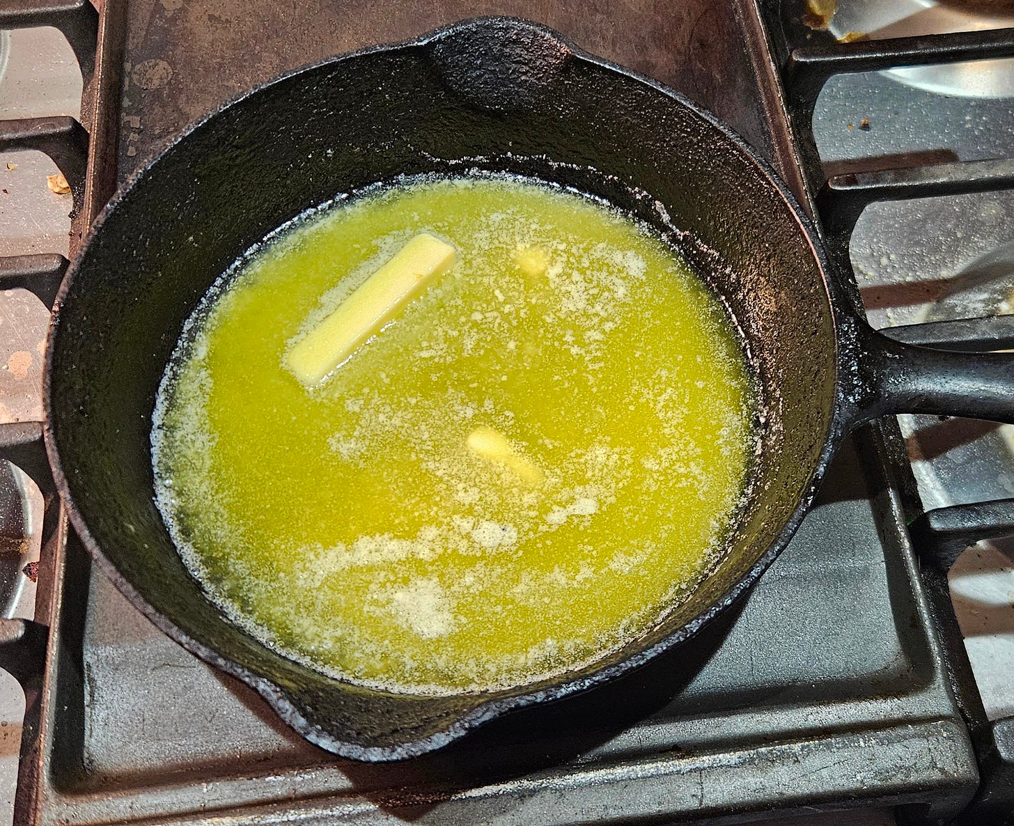 cast iron frying pan with butter starting to melt
