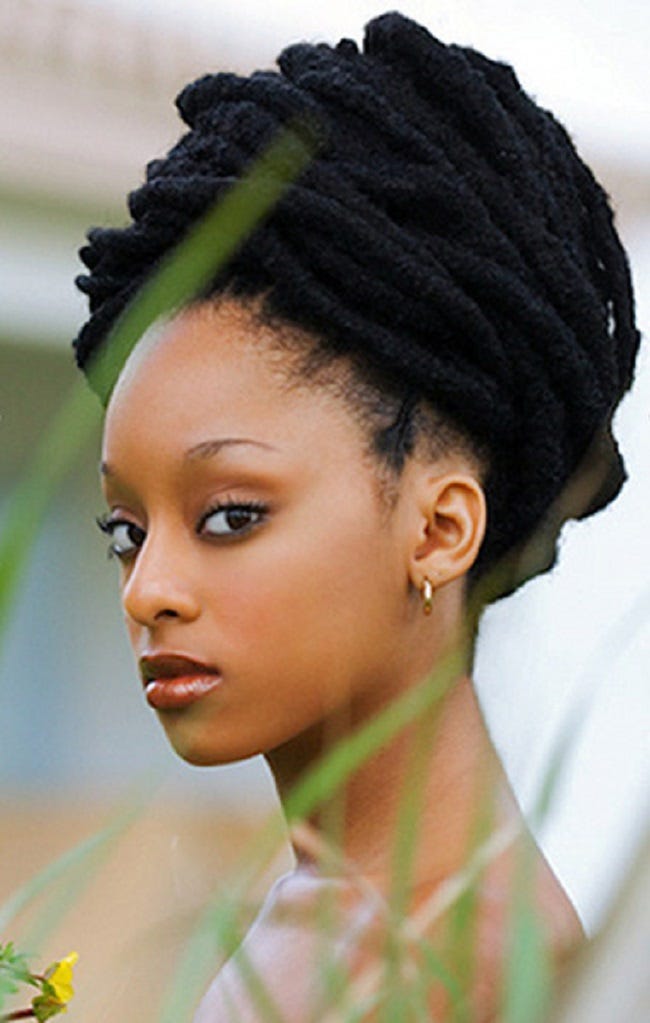 Nerissa irving standing in tall grass, gazing at the camera. Her long locs are wrapped in a turban-style updo around her head Nerissa irving standing in tall grass, gazing at the camera. Her long locs are wrapped in a turban-style updo around her head