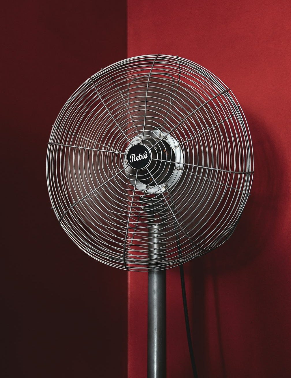black stand fan turned on in red room