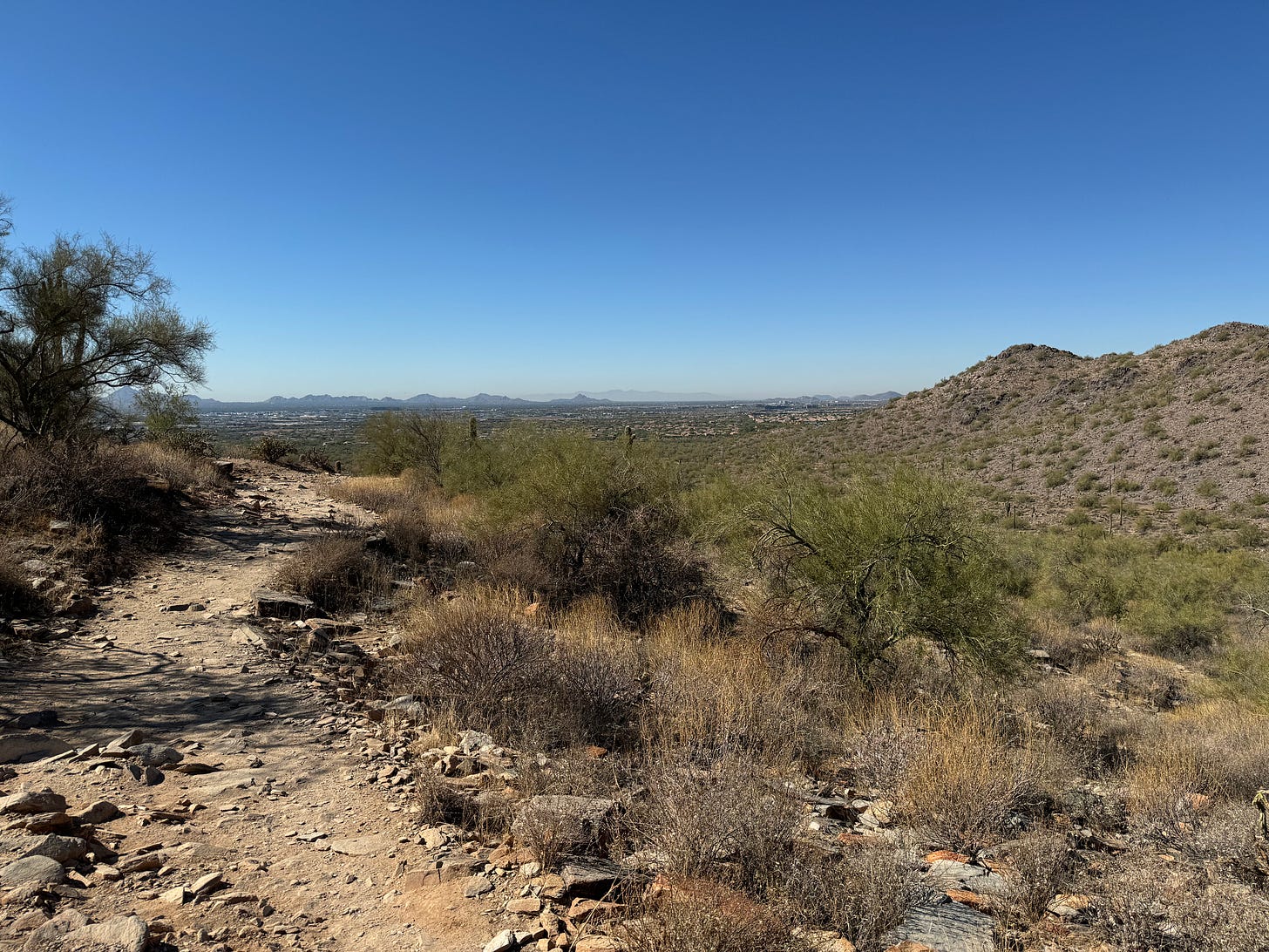 Rocky desert hiking trail overlooking the Phoenix Valley with mountains and blue sky in Arizona. Rocky desert hiking trail overlooking the Phoenix Valley with mountains and blue sky in Arizona.