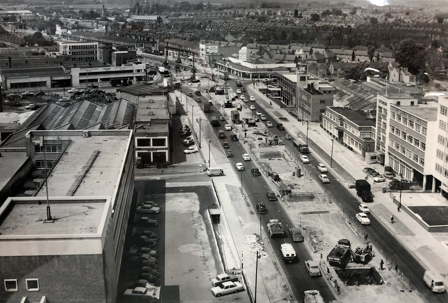 Archive photograph of the A4 Great West Road with work happening in the central reservation to dig deep foundation pits. Heavy traffic navigates narrow roadways through the worksite.