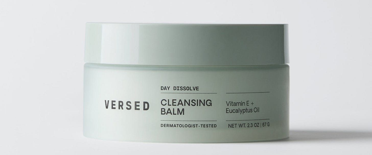 Versed Day Dissolve cleansing balm in a pale green jar with white lid, labeled with Vitamin E and Eucalyptus Oil ingredients. Versed Day Dissolve cleansing balm in a pale green jar with white lid, labeled with Vitamin E and Eucalyptus Oil ingredients.