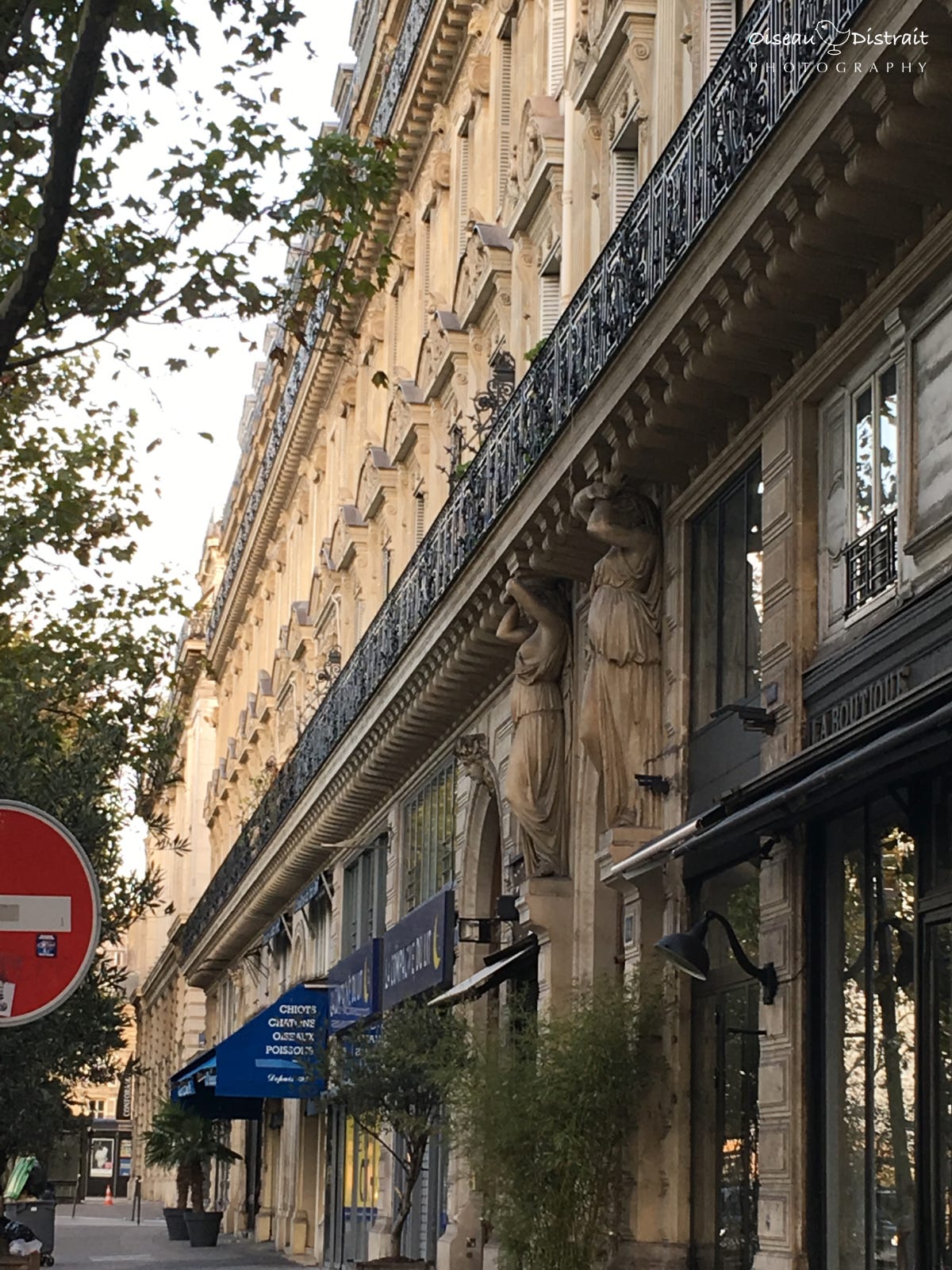 A photo of the façade of 14 quai de la Mégisserie with two stone female sculpture at doorway entrance.