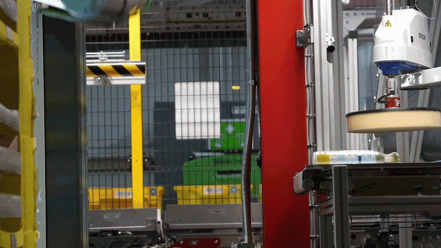 Amazon Vulcan robot picking up Febreze bottle