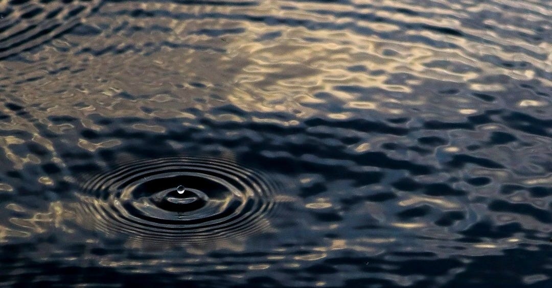water drop on brown sand water drop on brown sand