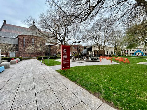 scupltures, signs, sidewalk, sky, grass, trees
